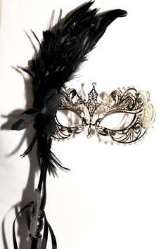 This is gorgeous gold masquerade mask that I just added to the large variety of different designs of metal masks and lace embroidered masks. This mask is a metal gold mask decorated with shimmered white rhinestones to enhance the design of the mask and the facial features This mask has a mask handle and decorated with a black flower and gorgeous black rooster feathers! I hope you love this mask! If you wish this mask to be without a stick please feel free to leave a note in the order that you wi Elegant Masquerade Mask For Mardi Gras, Elegant Mardi Gras Masquerade Eye Mask, Elegant Mardi Gras Masquerade Mask, Elegant Mardi Gras Eye Mask, Gold Gothic Masquerade Mask For Carnival, Gothic Gold Masquerade Mask For Carnival, Elegant Masquerade Eye Mask, Elegant Masquerade Mask For Carnival, Elegant Eye Mask For Theater