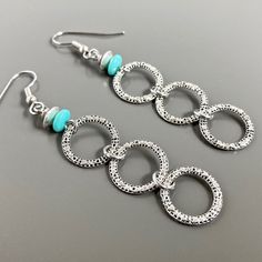 "Silver Hoop Earrings - Small connected Silver Pewter Hoops dangle from Turquoise Czech Glass Beads. The hoops have a pretty texture. Surgical Steel Earwires The hoops are 14mm in diameter (slightly over .5\") Earrings measure just over 2.75\" from top of earwires to bottom of beads." Turquoise Metal Hoop Earrings, Nickel-free Turquoise Metal Hoop Earrings, Turquoise Metal Round Hoop Earrings, Turquoise Metal Jewelry With Ear Wire, Turquoise Hoop Metal Jewelry, Turquoise Metal Hoop Jewelry, Small Hoop Turquoise Nickel-free Earrings, Nickel-free Turquoise Small Hoop Earrings, Turquoise Nickel-free Small Hoop Earrings