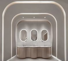 a bathroom with three sinks and mirrors on the wall, along with arches in the ceiling