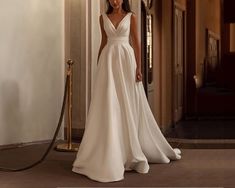 a woman in a white wedding dress standing next to a doorway