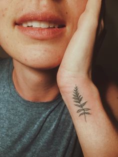 a woman with a small tattoo on her left arm and the other half of her neck