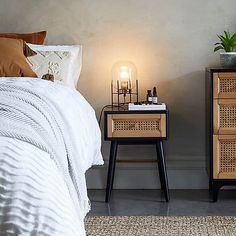 two nightstands with candles on them in a bedroom