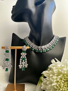 Introducing our stunning emerald silver jewelry set, perfect for adding an elegant touch to any reception outfit. Handcrafted by skilled artisans, this set features a dazzling emerald stone surrounded by intricate silver detailing. The necklace boasts a delicate chain that sits beautifully on the collarbone, allowing the emerald centerpiece to steal the show. The matching earrings complete the look with their simple yet stylish design, making them the perfect choice for anyone wanting to add sop Indian Wedding Jewelry Sets, Reception Outfit, Silver Jewelry Set, Wedding Jewelry Set, Silver Jewellery Sets, Indian Wedding Jewelry, Delicate Chain, Emerald Stone, Wedding Jewelry Sets