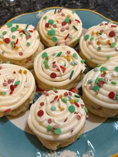 cupcakes with white frosting and sprinkles on a blue plate