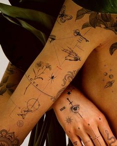 a woman's legs with tattoos on them and her hand resting on the ground