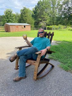 a man sitting in a rocking chair holding a glass of wine