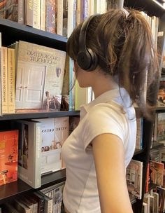 a woman wearing headphones looking at books