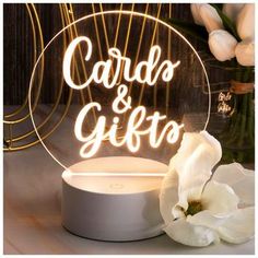 a light up sign that says carda and gitto on it next to flowers