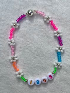 "Handmade, 7 inch, Neon Rainbow seed bead Bracelet. Super cute Bracelet, perfect for layering and beautiful to wear on its own as well. Available with or without personalization (name/date/initials). Makes a great gift and is perfect for friendship bracelets! Every bracelet is finished with a magnetic clasp for easy wearing. Primary color refers to the color in the center of the Daisy. The \"Clear\" primary color is available in glow-in-the-dark and a rainbow/AB finish. If selecting a non-metall Multicolor Tiny Beads Jewelry For Birthday, Handmade Colorful Friendship Bracelets For Birthdays, Handmade Flower Shaped Beaded Bracelets For Birthday, Personalized White Beaded Bracelets For Festival, Handmade Flower Shaped Beaded Bracelet For Birthday, Handmade Flower Beaded Bracelet For Birthday, Personalized White Bracelets For Festival, Personalized White Bracelets For Festivals, White Beaded Bracelets With Tiny Beads For Birthday