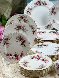 a table topped with lots of white and pink plates