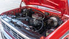 the engine compartment of a red car with its hood open