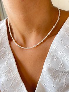 Embrace the elegance and simplicity of our Dainty Minimalist Freshwater Pearl Necklace. This delicate piece is meticulously crafted with natural freshwater seed pearls, interspersed with 3mm natural pearls. The clasp and extender chain are gold plated stainless stell, adding a luxurious touch to this minimalist design. Features: *Material: Natural freshwater seed - 3mm natural pearls and stainless steel / Gold plated stainless stell clasp and extender chain *Length: 35cm + 4cm extender chain Car Delicate White Necklace With Pearl Charm, Dainty White Necklace With Pearl Drop, Dainty White Pearl Drop Necklace, Delicate Single Strand Bridal Necklace, Minimalist Single Strand Beaded Necklace, Minimalist Pearl White Necklace With Tiny Beads, Minimalist Pearl White Pearl Necklace With Tiny Beads, Dainty Single Strand Beaded Necklaces For Wedding, Minimalist White Beaded Necklaces For Everyday