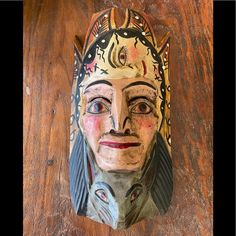 a wooden table with a carved mask on it's face and two different colored eyes