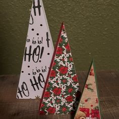 two small christmas trees sitting on top of a wooden table next to eachother