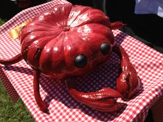 a red and white checkered table cloth with a fake crab on it's head