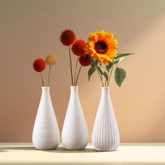 three white vases with sunflowers in them on a table next to a wall