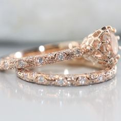 two gold wedding rings with diamonds on the top and one has an oval shaped diamond