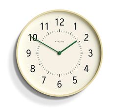 a white clock with green hands and numbers on the face is shown against a white background