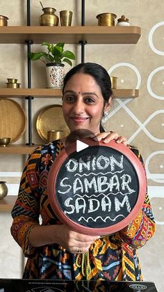 a woman holding up a sign that says onion sambar gajam on it