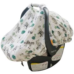 an infant car seat cover with zebras and leaves printed on it, in front of a white background