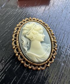 Here we have a beautiful vintage cameo brooch. Gold metal in a lace-like pattern around the entire cameo. Marked WMCA on the back. With a safety clasp. Very detailed metalwork. Measurements:1.75 inches across and 2 inches high. Weighs 1 ounce. Perfect for yourself or to give as a gift. Enjoy Free Shipping on All of my items to the Continental USA. (unless otherwise noted) All my items are Vintage or Antique and keep in mind items are not new. Items have had a life before their soon-to-be new home. All items are hand-picked by the shop owner. A thrift shop, antique market, and garage sale enthusiast, Doing the footwork so you don't have to. I am not a big box company or a wholesaler. I just enjoy passing along some of my finds to their new homes for others to enjoy as well. All of my items Classic Cameo Brooches For Wedding, Victorian Style Cameo Brooch For Weddings, Victorian Cameo Brooch For Wedding, Box Company, Vintage Cameo, Thrift Shop, Antique Market, Cameo Brooch, Shop Owner