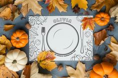 a place setting surrounded by autumn leaves and pumpkins