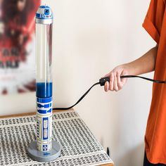 a person is plugging in to an electric device on a table with a white wall behind them