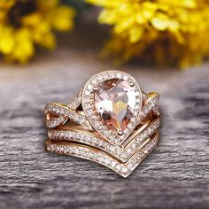 an image of two wedding rings on top of each other with flowers in the background