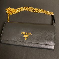 This New Fabulous Sleek Accessory Comes With Luxurious Saffiano Leather. It Has 2 Main Pockets, One Zip Pocket 6 Card Slots, And It Is Very Easy To Maintain And Clean. Authentic, Never Used, Detachable Chain, Dust Bag Included. Certificate Of Authenticity Included. Luxury Gold Wallet On Chain For Business, Elegant Gold Wallet On Chain With Chain Detail, Elegant Gold Wallet On Chain For Business, Elegant Gold Wallet On Chain, Elegant Gold Wallets For Business, Luxury Gold Wallet On Chain With Chain Detail, Gold Luxury Wallet On Chain With Details, Black Business Clutch Wallet On Chain, Black Wallet On Chain With Gold-tone Hardware For Business