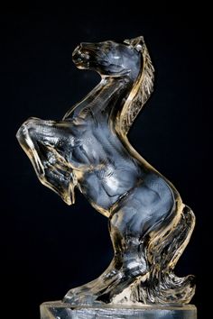 a glass horse statue sitting on its hind legs