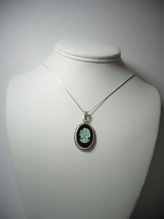 Precious Opal Cameo on Black Onyx .999 Fine Silver Bezel Pendant with Twisted Wire Accent A beautiful precious opal cameo exhibiting moving flashes in multi-colors of light within a clear to white opal stone against a solid black onyx background stone displays; wears well with most colors; typically better with dark, medium or light colors versus earth tone and bright colors, as the multi-color reflections are more distinct against clear contrasting colors, earth tones tend to dull the brilliant Handmade Black Opal Jewelry, Black Oval Opal Jewelry, Oval Black Opal Jewelry, Light Reflection And Refraction, Background Stone, Reflection And Refraction, Precious Opal, Black Onyx Stone, Flash Light