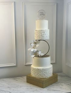 a three tiered wedding cake with white flowers on top