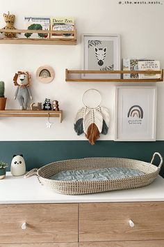 a baby crib in the corner of a room with shelves and pictures on the wall