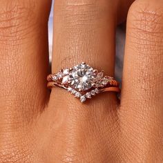 a woman's hand with an engagement ring on it and two diamonds in the middle