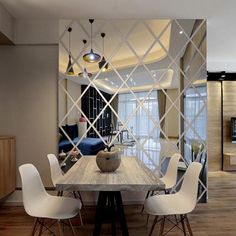 a dining room table with white chairs and a mirror on the wall in front of it