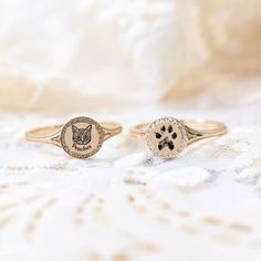 two gold rings with an image of a cat and a dog's paw on them