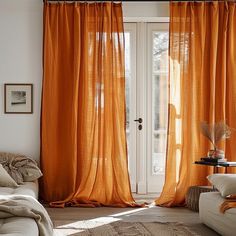 a living room with orange drapes on the windows