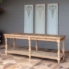 an old wooden bench sitting in front of two paintings on the side of a wall