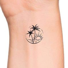 a small palm tree tattoo on the right side of the ankle, with an island in the background