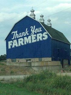 a blue barn with the words thank you farmers written on it's side in white lettering