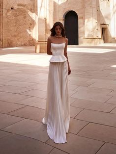 a woman in a white dress standing on the ground