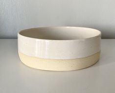 a white and beige bowl sitting on top of a table