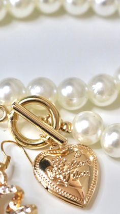 Elegant and Beautiful. Introducing our first ever necklace. A pearl and heart shaped neck piece with a locket to store an image of your loved one(s). Keeping them close while looking stunning! ﻿Not real pearls nor real gold. ✨ ﻿Beauty on a budget! ✨ ﻿(alloy & pearl) Pearl Necklace For Anniversary On Valentine's Day, Gold Heart-shaped Pearl Pendant Jewelry, Gold Pearl Jewelry With Heart Charm, Gold Pearl Necklace With Heart Pendant And Beads, Gold Pearl Jewelry With Heart Beads, Gold Heart Necklace With Pearl Charm For Valentine's Day, Gold Pearl Heart Necklace For Valentine's Day, Gold Heart-shaped Jewelry With Pearl Charm, Gold Pearl Necklace With Heart Charm And Pendant