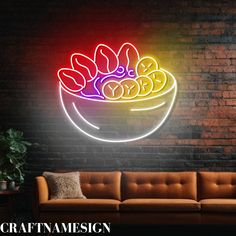 a colorful neon sign with bananas in a bowl on the wall next to a couch