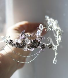 a close up of a person holding a tiara with flowers on the headband