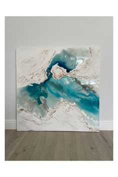 an abstract painting with blue and white paint on the wall in a living room or bedroom