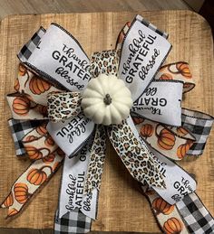 a pumpkin and leopard print ribbon on a wooden board with the words, grateful grateful grateful grateful