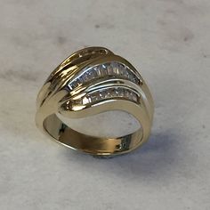 A stunning 14kt Yellow Gold Lady's Cubic Zirconia Baguette Channel Set Band with 1.50ct approx. total weight of all channel set straight baguette Cubic Zirconia (CZ) stones in finger size 7. This ring can be resized for an additional $95.00 upon request. The ring weighs 7.25 grams. Excellent band as a Wedding/Anniversary Gift. This item would Retail for $1,279.00 Channel Set Baguette Rings For Anniversary, Baguette Channel Set Rings For Anniversary, White Gold Baguette Channel Set Jewelry, 14k Gold Jewelry With Baguette Diamonds In Diamond White, Dazzling Cubic Zirconia Ring With Baguette Diamonds, Timeless Cubic Zirconia Jewelry With Baguette Diamonds, Channel Set Diamond Ring With Baguette Cut Cubic Zirconia, Yellow Gold Baguette Jewelry With Channel Set, Baguette Cut Diamond Ring With Channel Set Cubic Zirconia