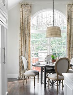 a dining room table with four chairs and a lamp hanging from the ceiling over it