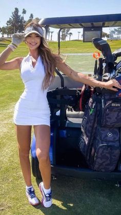 a beautiful woman standing next to a golf cart